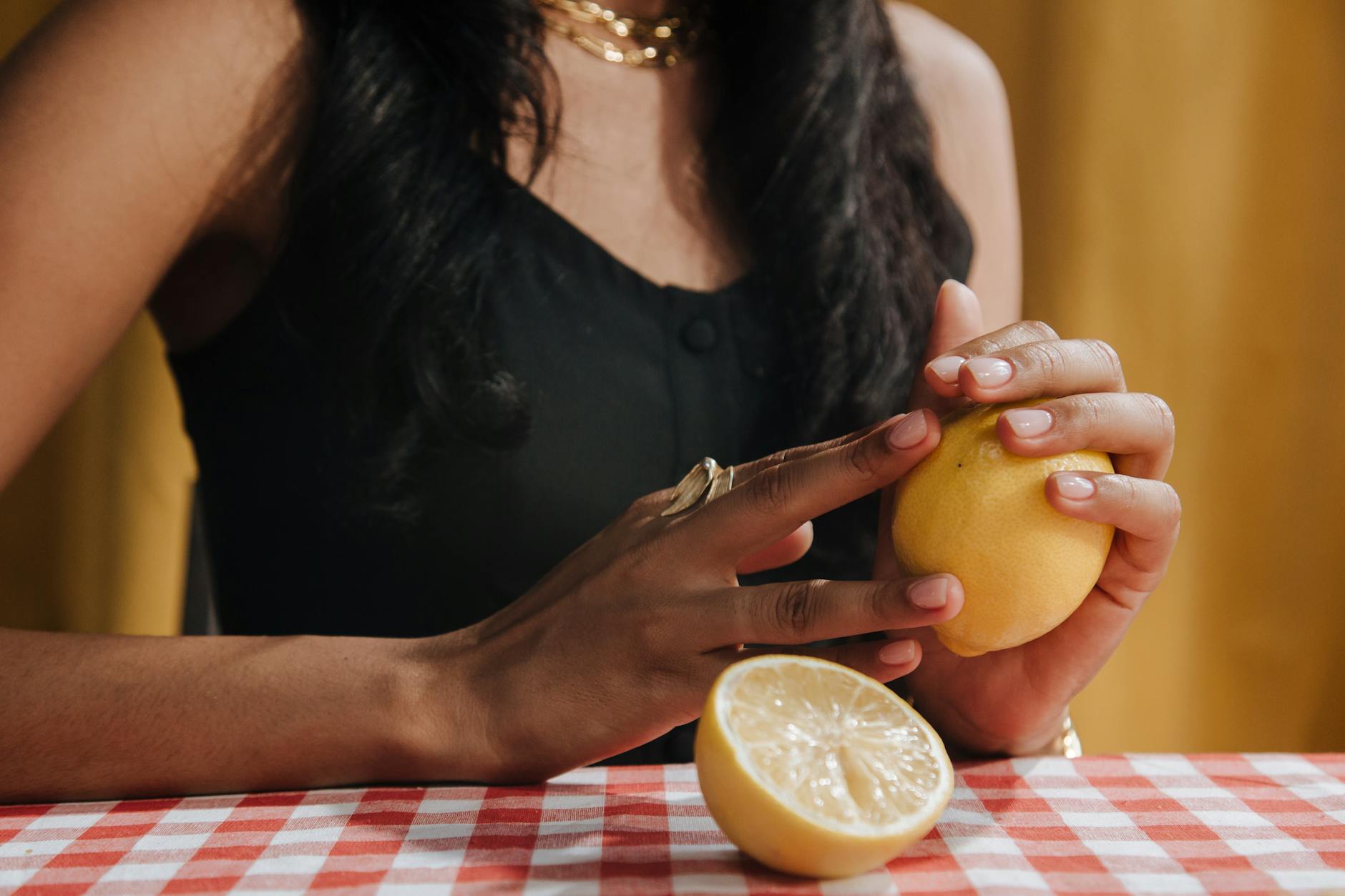Close-up of hands holding a fresh lemon, symbolizing the bright, focused design of lemon clitoral vibrators