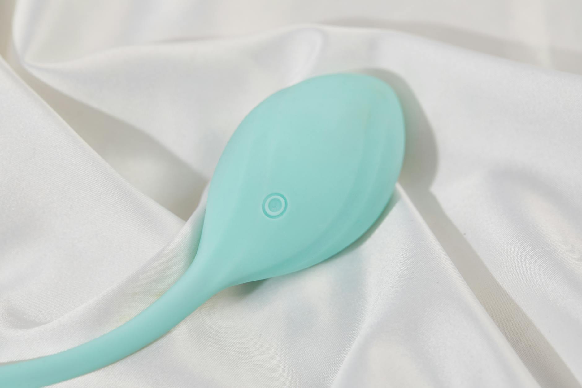 A sleek vibrator resting on soft white fabric, symbolizing safe self-touch and body reclamation