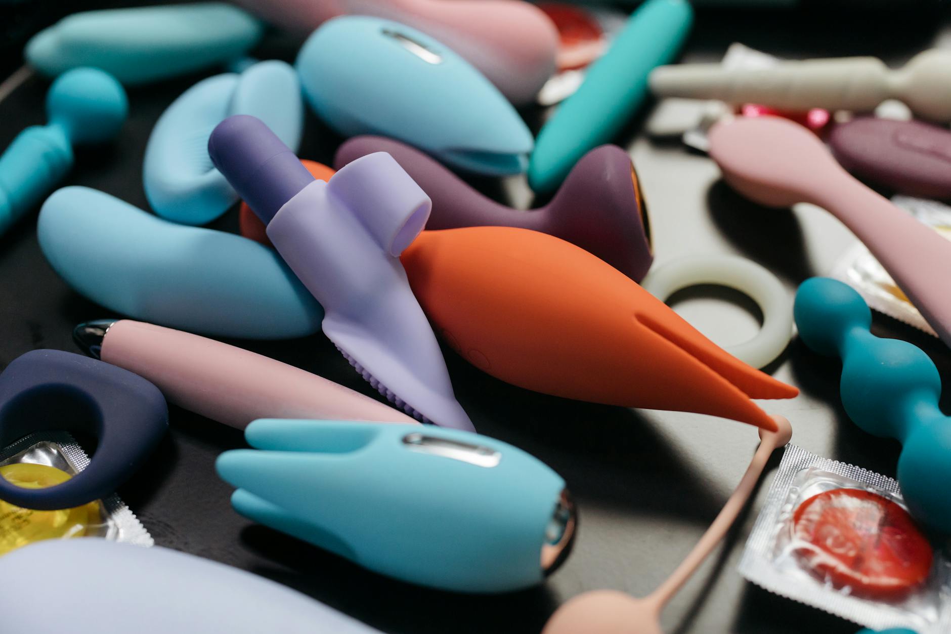 Close-up display of vibrant clitoral vibrators in various colors, illustrating modern pleasure tools for nervous system regulation.