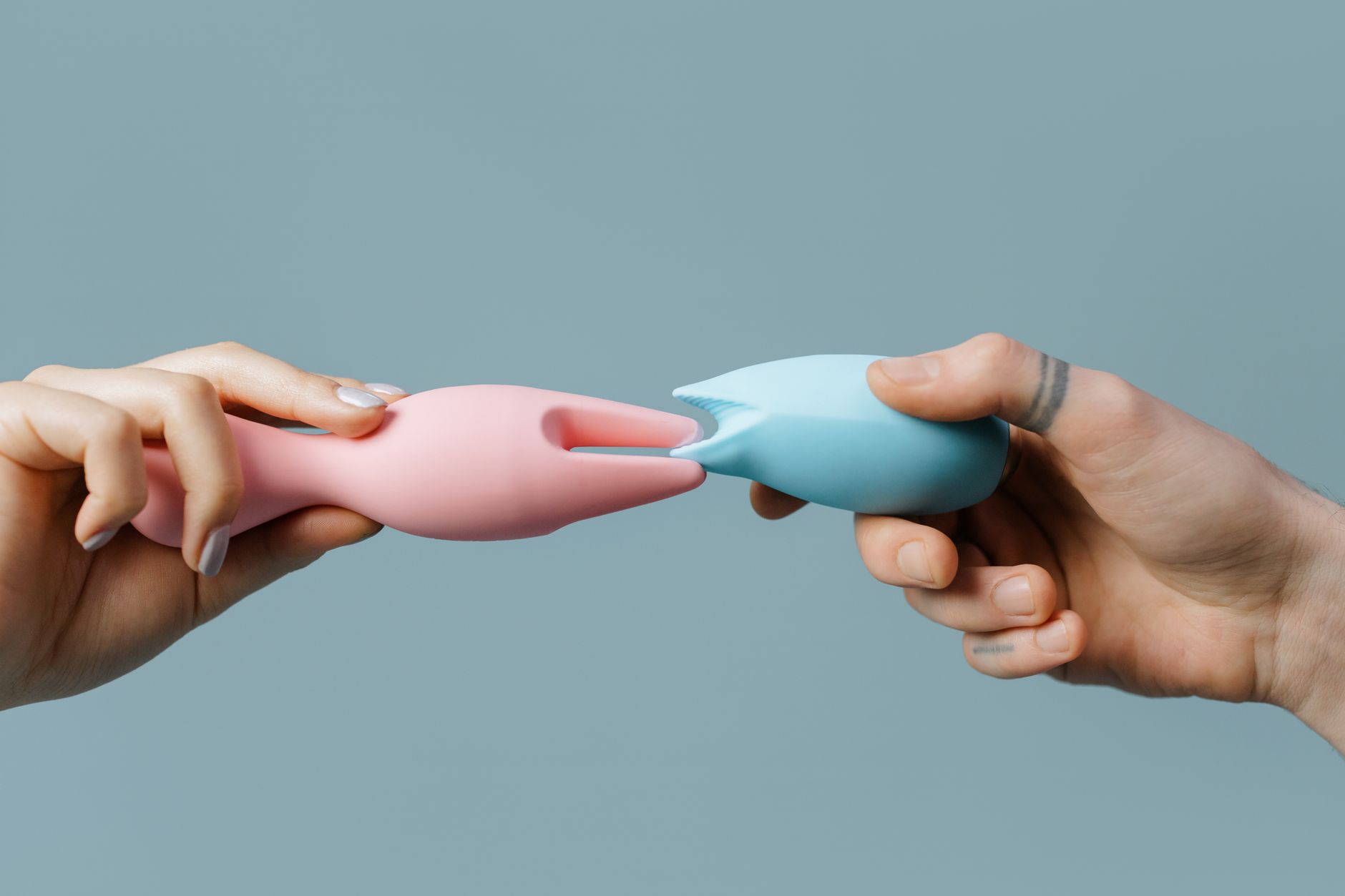 Woman holding vibrators, considering pleasure after hormonal changes