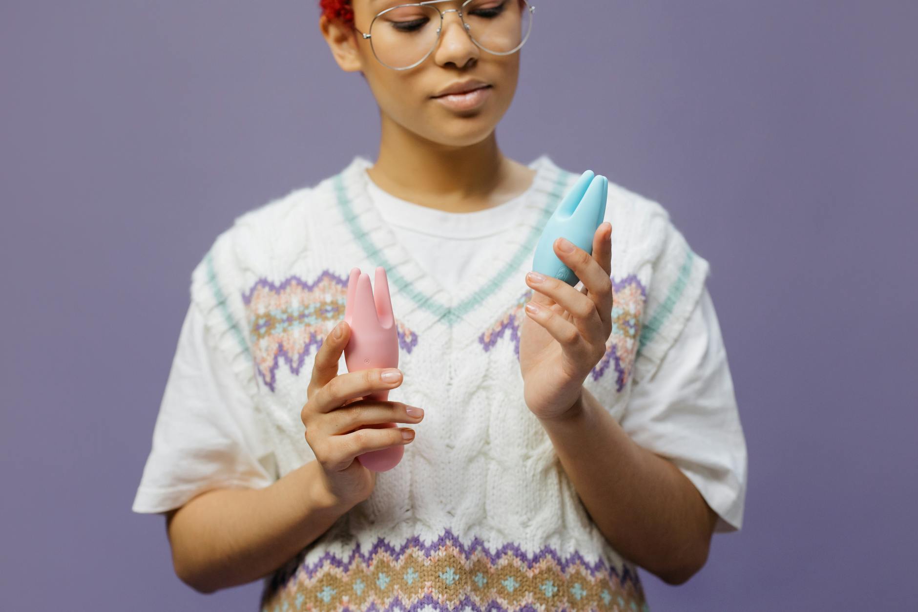 Person with sensitive skin holding a blue silicone vibrator with care and consideration.