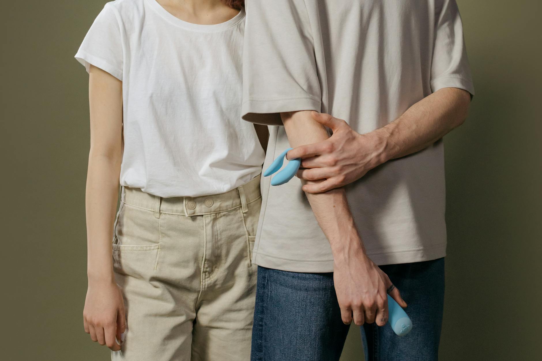 A couple holding a vibrator together, representing shared intimacy and synchronized pleasure.