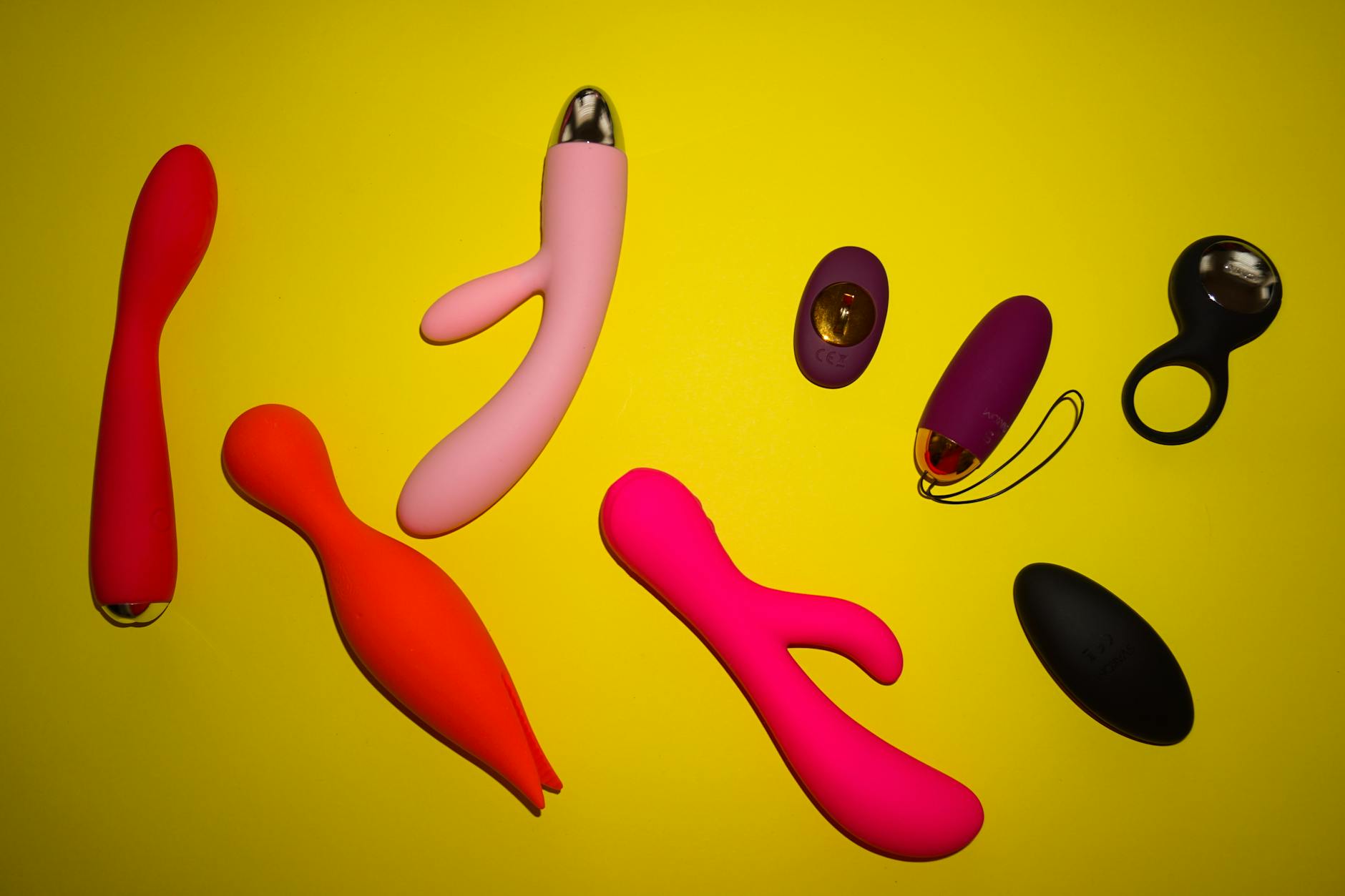 Woman holding a pink vibrator with art books visible in the background